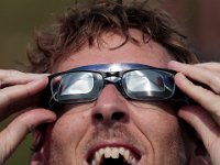 UMass Dartmouth biology professor, Mark Silby takes two sets of glasses to view the eclipse while joining hundred who stood in front of the UMass Dartmouth observatory to view the partial solar eclipse that swept over the area.   [ PETER PEREIRA/THE STANDARD-TIMES/SCMG ]